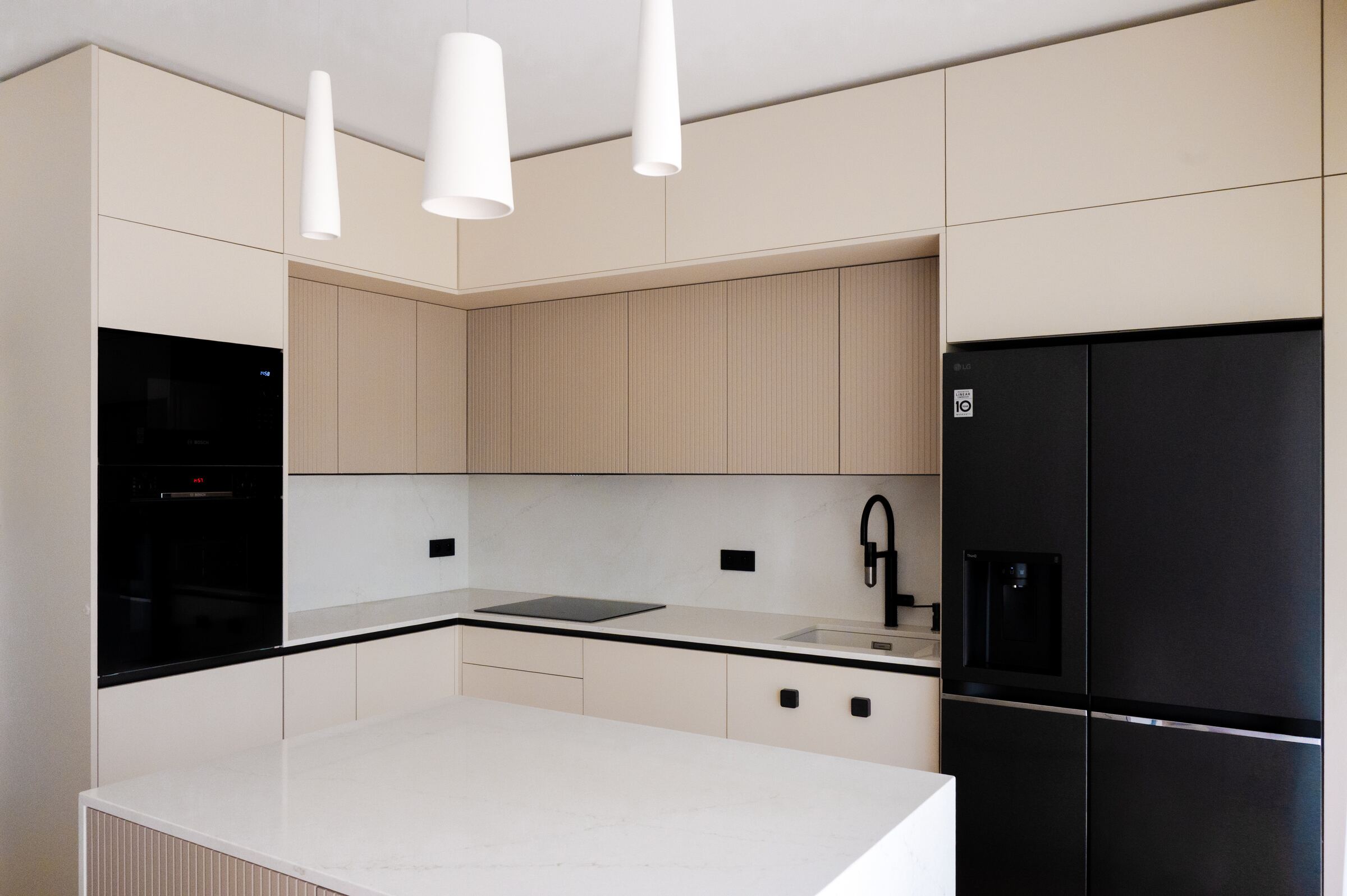 Kitchen with cream fronts, a white island and black accents — Prague Apartment project